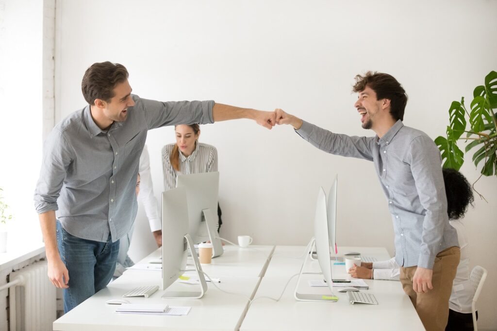 Deux hommes au bureau qui se checkent